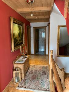 米特西尔Gästehaus Wimmer的走廊上设有红色的墙壁和一张带蜡烛的桌子