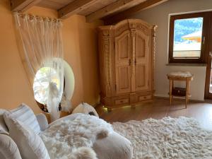 米特西尔Gästehaus Wimmer的卧室配有白色的床和大橱柜。