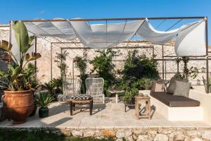 诺托Dimora delle Balze的庭院配有椅子、沙发和天篷