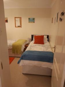 邓弗姆林Homely Haven, Dunfermline的一间卧室配有两张床和红色枕头