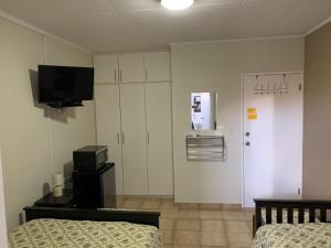 威廉斯塔德Eve's Residence的客房设有两张床和一台墙上的电视。