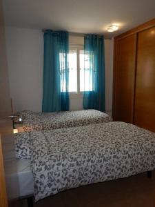托雷帕切科2-bedroom Villa with pool的一间卧室配有床和蓝色窗帘的窗户