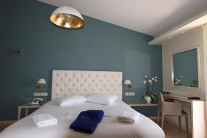 托隆维瑞斯公寓酒店的卧室配有白色大床和蓝色的墙壁