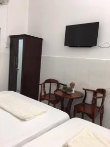龙川市Nhà nghỉ Hoàng Huân的一间卧室配有两张床和一台平面电视