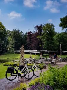 莱尔瑟姆Parc Broekhuizen l Culinair landgoed的两辆自行车停在公园的雕像旁边
