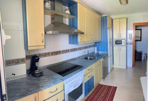 阿尔梅利马Apartamentos San Miguel 2的厨房配有蓝白色橱柜和水槽
