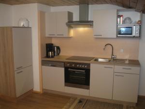 RohrbergRossruckhof的厨房配有白色橱柜、水槽和炉灶。