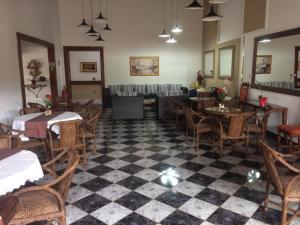 特马斯多伊比拉Pousada Aguas de Ibira的一间带桌椅和 ⁇ 制地板的餐厅