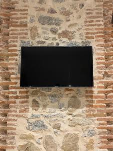 阿维拉Santa Suites的石墙上的平面电视