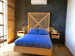 圣米格尔-德阿连德Canela Fina - Adults Only的一间卧室配有一张大床和木制床头板
