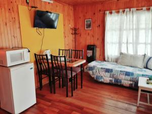波特雷里约斯Cabañas Las Golondrinas的客房设有床、桌子和微波炉。