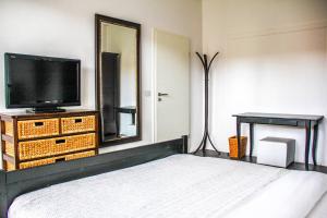 不莱梅EXKLUSIVE 2 Zimmer Wohnung mit Balkon in Top Lage!的一间卧室配有一张床、一台电视和一面镜子