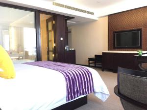 杭州杭州西溪谷君亭酒店的配有一张床和一台平面电视的酒店客房