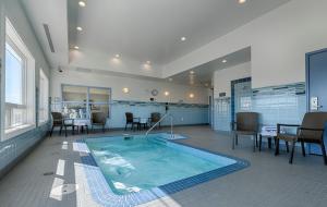 Assiniboia阿西尼波亚卡纳尔塔酒店的一个带桌椅的房间的大型游泳池