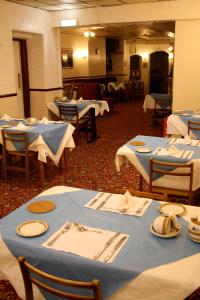 布莱克浦观景楼酒店的一间用餐室,配有蓝色的桌椅和餐巾