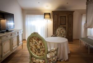 雷吉奥洛纳比拉别墅酒店的客厅配有桌子和两把椅子