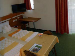 巴特乔京福耳图那公寓式酒店的酒店客房设有两张床、一张桌子和电视。