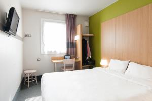 布吕热B&B HOTEL Bordeaux Lac sur Bruges的一间酒店客房,配有一张白色的床和一张书桌