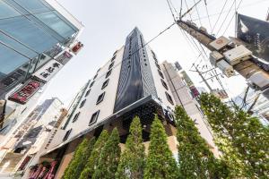 首尔Forestar Hotel Sinchon的前面有树木的高楼