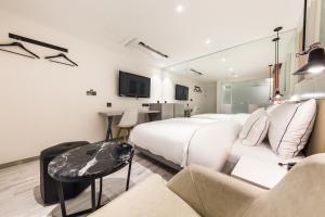 首尔Forestar Hotel Sinchon的酒店客房设有两张床和一张桌子。