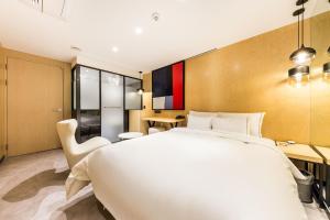 首尔Forestar Hotel Sinchon的卧室配有一张白色大床和一张书桌