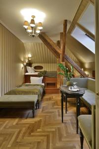 布达佩斯Gerlóczy Boutique Hotel的一间设有四张床、一张桌子和吊灯的客房