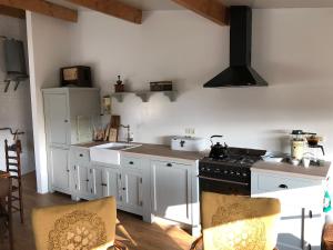 SilvoldeHalte Bontebrug的厨房配有白色橱柜和炉灶烤箱。