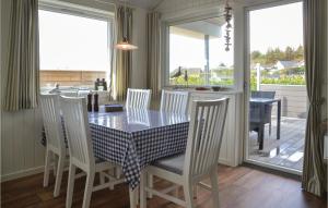 埃斯比约Pet Friendly Home In Esbjerg V With House Sea View的一间用餐室,配有桌椅,享有门廊的景色