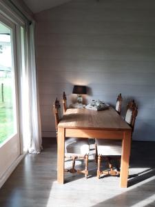 WijnjewoudeB&B Stripsein的窗户客房内的一张带椅子的木桌
