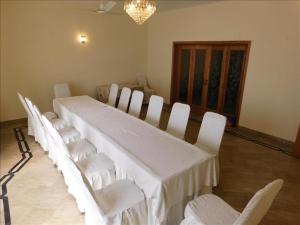 伊斯兰堡Melberry House的客房内的一张长白桌子和椅子