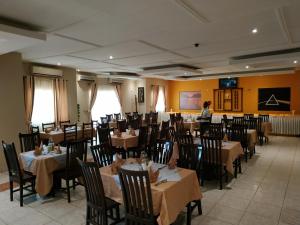 朱巴Quality Hotel Juba的一间配备有桌椅的用餐室,以及一名背景女性