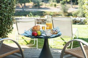 格吕桑Hotel Le Phoebus Garden & Spa的桌椅上的一盘早餐食品