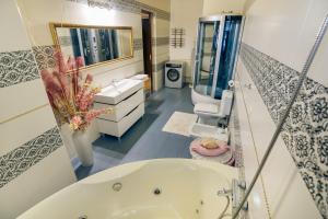 利沃夫Saban Deluxe的带浴缸、两个盥洗盆和镜子的浴室