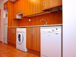 摩拉鲁比罗奥塔兰公寓的厨房配有洗衣机和木制橱柜。