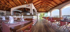 希杰弗朗吉卡Happy Camp mobile homes in Camping Amadria Park Camping Trogir的餐厅设有木制天花板和桌椅