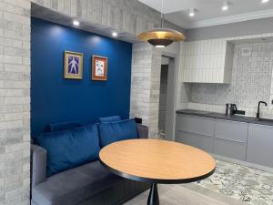 利沃夫Kraft Boutique Apart-Hotel的客厅配有蓝色的沙发和桌子