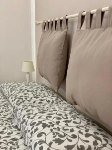 都灵Re Vittorio的一间卧室配有带两个枕头和一盏灯的床
