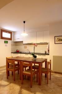 滕诺Al Trovante - Gardaslowemotion的厨房配有带椅子的木桌和花瓶