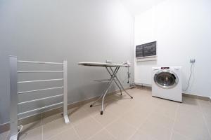 下诺夫哥罗德Vesna Hotel的洗衣房配有洗衣机和桌子