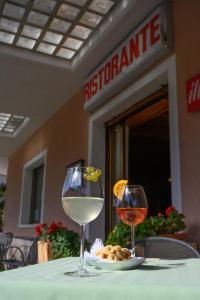 维塔罗多露米体酒​​店的一张桌子,上面放着两杯葡萄酒和一盘食物