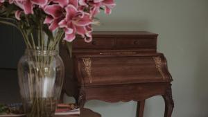 昆明昆明若安·对月楼酒店的一张桌子旁的花瓶,上面有粉红色的花朵