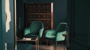 昆明昆明若安·对月楼酒店的两把绿色椅子,位于带镜子的房间