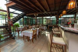 圣米格尔-阿尔坎茹Pousada Villa da Mata的餐厅设有白色的桌椅和窗户。