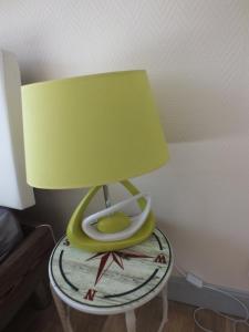 沙托鲁Residence Miranto的一张桌子上的灯,上面有绿灯罩