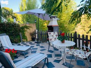 拉洛勒斯Barranco de la Salud的庭院配有桌椅和遮阳伞。