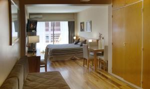 布宜诺斯艾利斯巴提蒙公寓的一间卧室配有一张床、一张桌子和一张沙发
