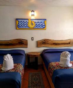 奇格纳瓦潘Hotel Tlatoani的客房设有两张床和一张带毛巾的桌子。