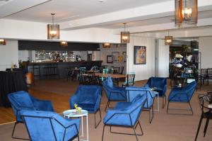 库德尔岛凯普奥克斯皮尔斯酒店的一间设有蓝色桌椅的房间和一间酒吧