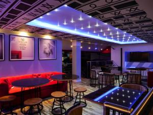 拉各斯Proof Hotel Lekki的酒吧设有红色的沙发、桌子和凳子