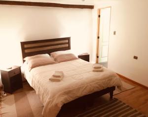 圣佩德罗·德·阿塔卡马拉卡萨德尔镇旅馆 的一间卧室配有一张大床和两条毛巾